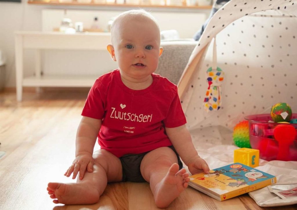 Ostseele-Zwutschgerl-Baby-spielt-mit-einem-Buch